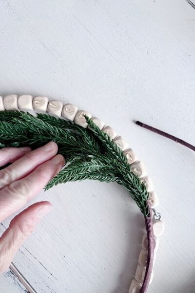 Pull the first evergreen branches back to glue the second pic's stem onto the other side.