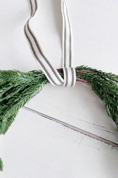 Wrap farmhouse style ribbon around the top of the wreath where the stems intersect.