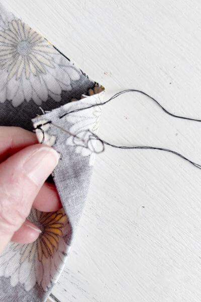 Push the needle back through the previous hole.