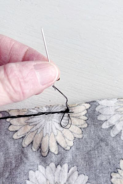Pull the needle through making the knot.