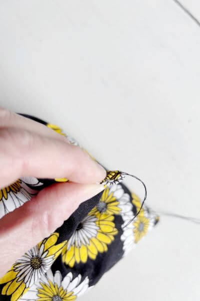 Pinch the top closed after folding down the edges of fabric.