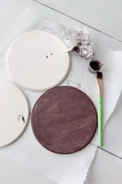 Paint wash the wood rounds with Burnt Umber paint and water.