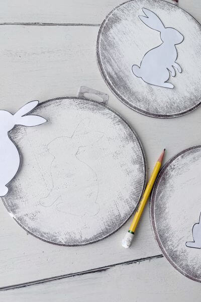 Bunny outline lightly traced on wood round.