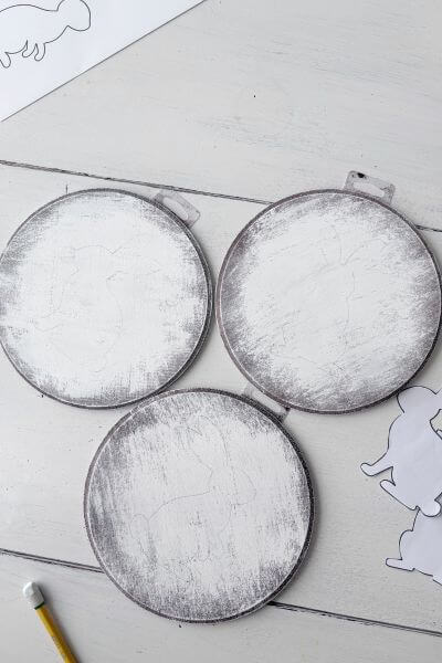 Three different bunny outlines traced onto the wood rounds.