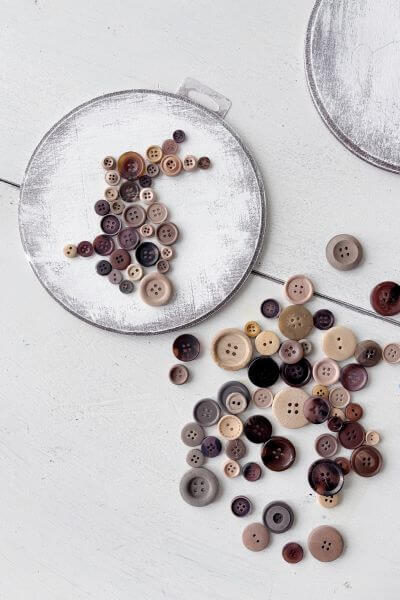 Buttons arranged in the shape of a bunny on the wood round.