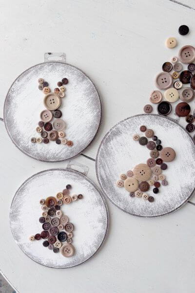 Three different bunny shapes arranged with buttons on the wood rounds.