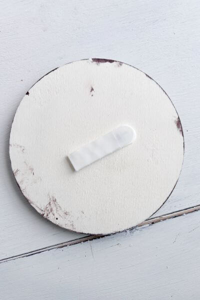 Command strip on back of wood round.