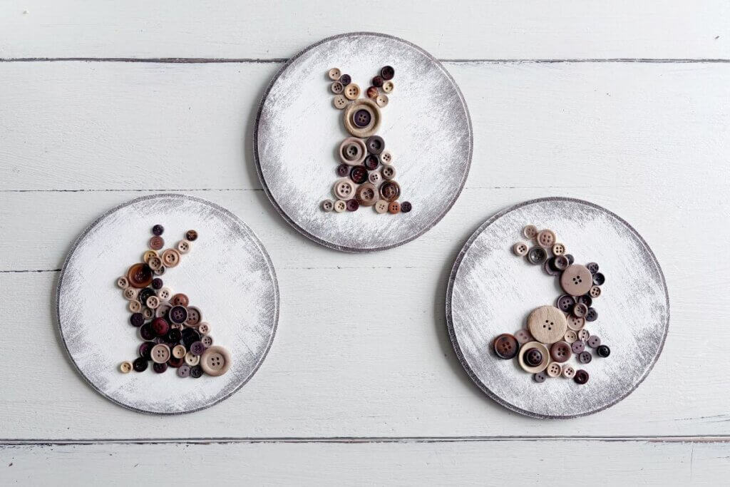 Three wood rounds with brown button bunnies.