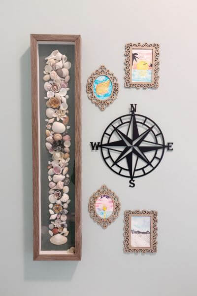 Shell picture, kids' art in frames and nautical wall compass.