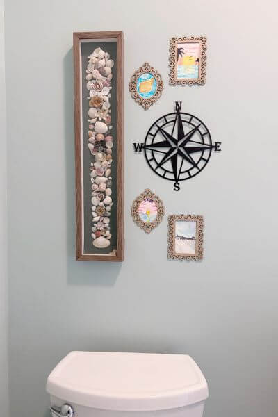 Beach themed display over toilet.