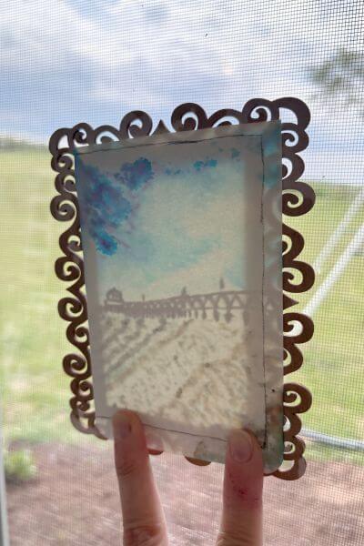 Hold the picture up to the light to trace where to cut the paper.